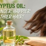 A small glass bottle of pure eucalyptus essential oil sitting next to fresh eucalyptus leaves and a wooden hairbrush.