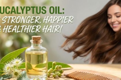 A small glass bottle of pure eucalyptus essential oil sitting next to fresh eucalyptus leaves and a wooden hairbrush.