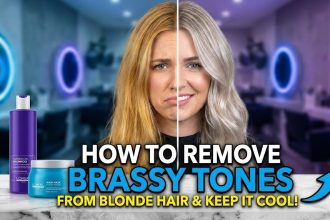 A woman with bright, cool-toned blonde hair looking over her shoulder after washing with a neutralizing purple shampoo.